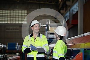 Young female engineer learning to run machinery at a factory with veteran engineers