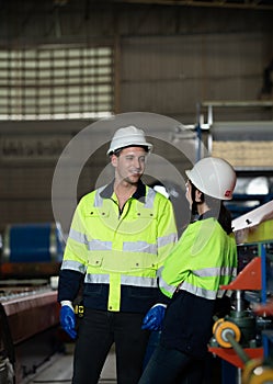 Young female engineer learning to run machinery at a factory with veteran engineers