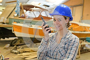 young female engineer talking on walkie talkie at factory