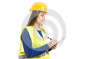 Young female engineer writing on clipboard