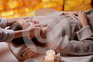 Young female enjoying facial massage at spa salon