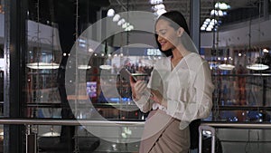 Young female entrepreneur reading electronic book on digital tablet in modern office interior, elegant businesswoman