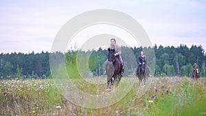 Young female equestrian galloping on horseback on the field