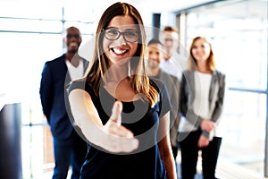 Young female executive standing with hand out