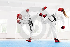 Young female fighter boxing using karate technique.