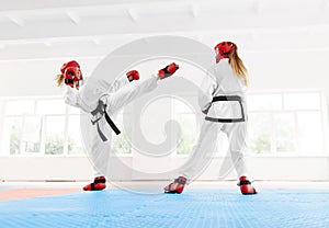 Young female fighter boxing using karate technique kick and punch.