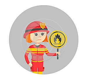 Young female firefighter holding a fire sign