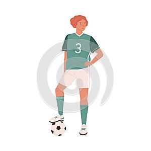 Young female football or soccer player standing with caught ball under her foot. Woman wearing green sports outfit