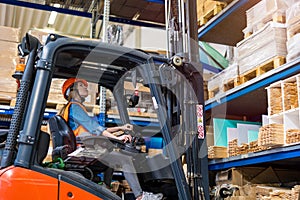 Young female forklift driver working in a warehouse