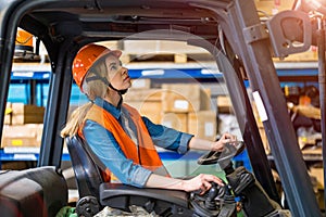 Young female forklift driver working in a warehouse