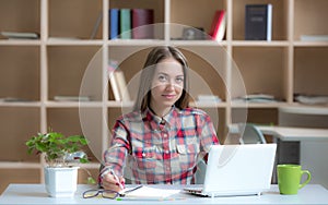 Young female Freelancer Professional working at desk in warm interior