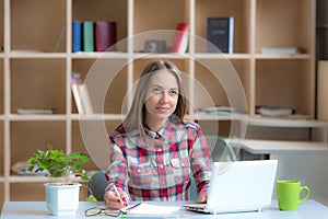 Young female Freelancer Professional working at desk in warm interior