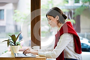 Young female freelancer working with laptop in spacy room