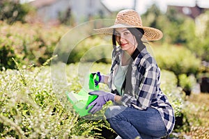 Young female gardener watering the plants in garden