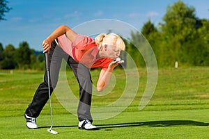 Young female golf player on course