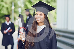 A young female graduate against the background of university graduates.