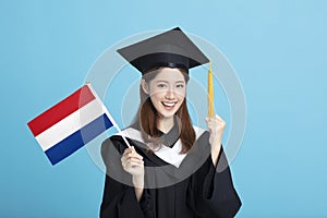 Young female graduation student showing the Netherlands  flag