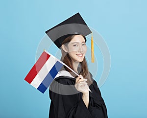 Young female graduation student showing the Netherlands  flag