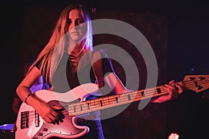 Young female guitarist performing in nightclub