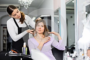 Young female hairdresser offering hairstyling to woman client