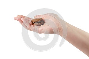 Young female hand holding chcolate macaron isolated on white