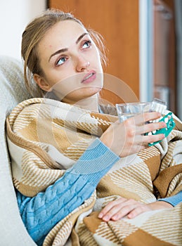 Young female having quinsy and fever and staying in couch photo