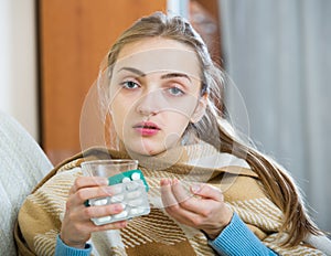 Young female having quinsy and fever and staying in couch photo