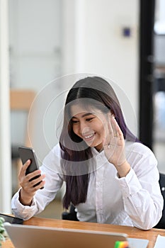 Young female having video call on smart phone with her friend.