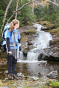 Young female hiker and river cascade