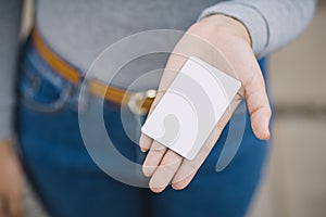 Young female holding blank credit card, outdoor