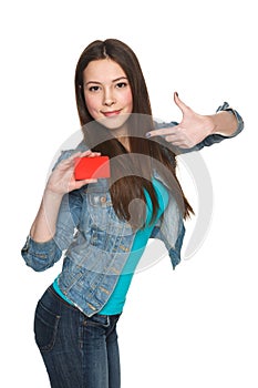 Young female holding blank credit card and pointing at it