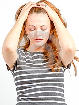 Young female holds head between hands emotionally