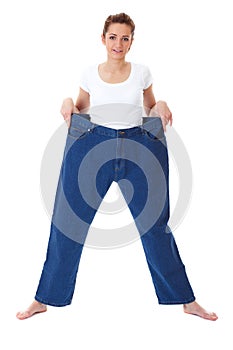 Young female holds her old huge jeans, diet