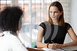 Young female hr manager holding job interview with african candidate.