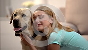 Young female hugging adorable labrador dog, housepet, best friend concept