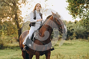 A young female jockey is sitting on her horse in show jumping training. Preparing for the competition.