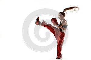 Young female kickboxing fighter training isolated on white background