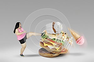 Young female kicking unhealthy foods