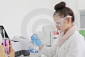 Young female Laboratory scientist working at lab with test tubes and microscope, test or research in clinical laboratory.Science,