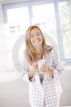 Young female laughing happily in pyjama