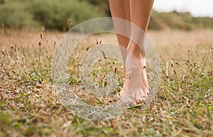 Young female legs walking on the grass