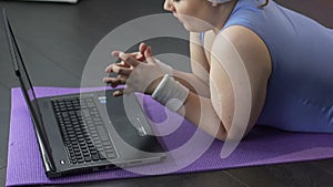 Young female looking at fingernails, then angrily at computer screen, annoyed