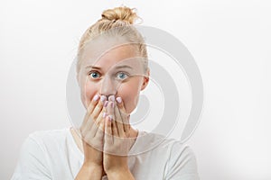 Young female looks with terrified expression, isolated over white background.