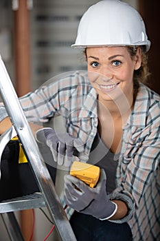 Young female maintenance engineer testing voltage