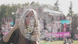 Young female makes soap bubbles