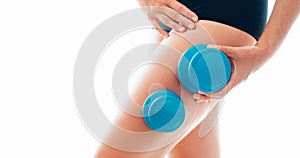 Young female making massage using a two silicone cups for vacuum Cupping anti-cellulite Massage Therapy on her thigh zone skin