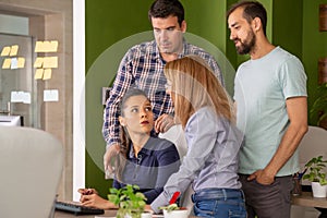 Young female manager having a conversation with her team in the office