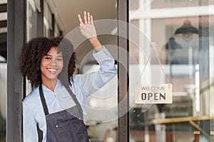 Young Female manager in restaurant with notebook. Woman coffee shop owner with open sign. Small business concept