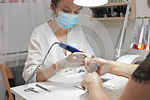 young female manicurist doing manicure for client