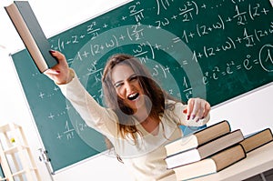 The young female math teacher in front of chalkboard